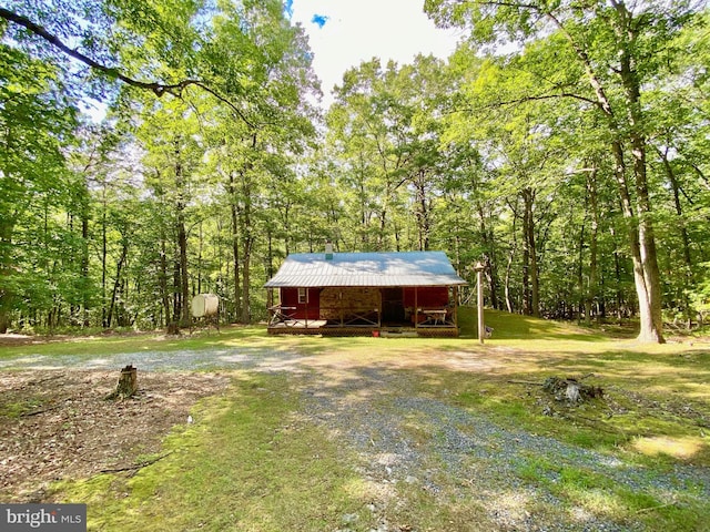 exterior space with driveway and a wooded view