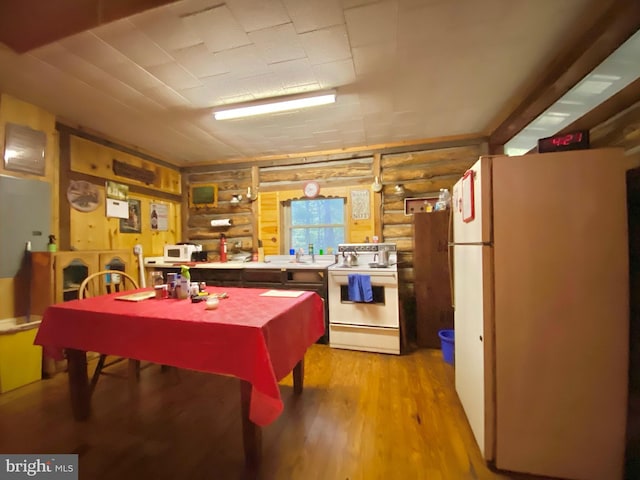 dining room featuring light wood-type flooring and rustic walls