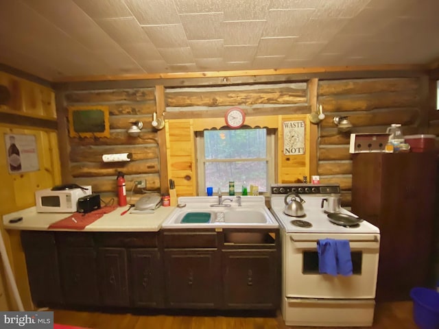 kitchen with white appliances, log walls, light countertops, and a sink