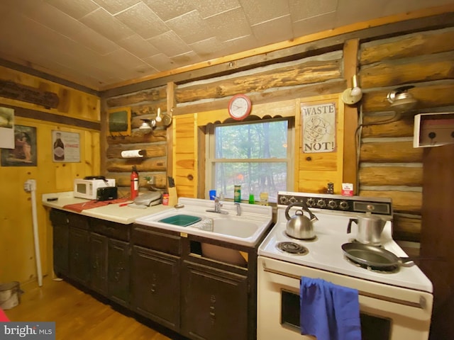 kitchen featuring white electric stove, a sink, light wood-style floors, light countertops, and log walls