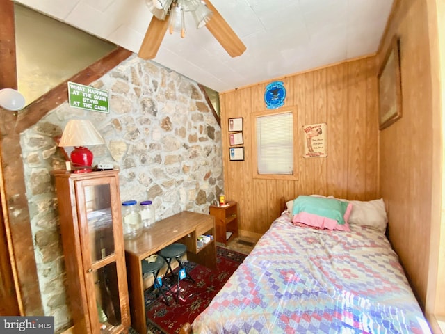 bedroom featuring wood walls and ceiling fan