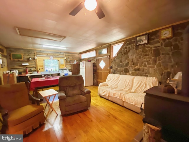 living room featuring a ceiling fan, attic access, and wood finished floors