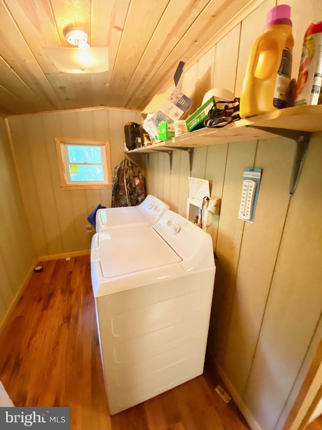 laundry room with washer and clothes dryer, dark wood-type flooring, wood ceiling, laundry area, and baseboards