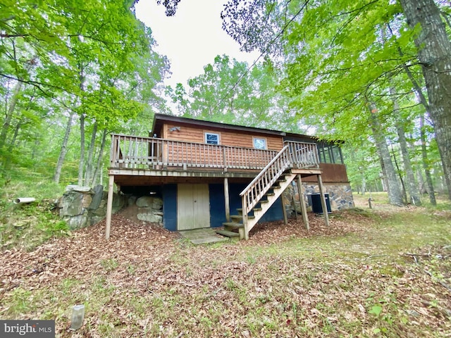 rear view of property with stairs and a wooden deck