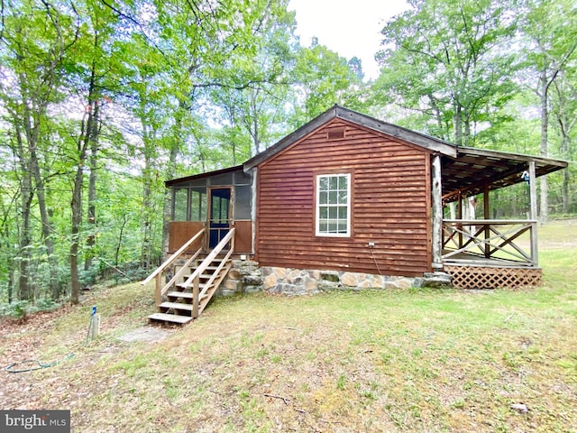 exterior space with entry steps, a yard, and a sunroom