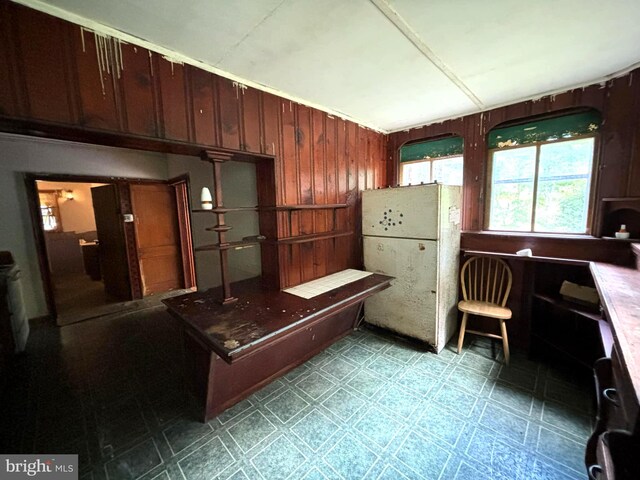 kitchen with wood walls and light tile patterned floors