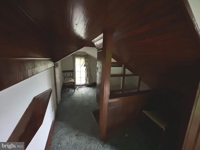 additional living space with lofted ceiling, wooden ceiling, and dark carpet