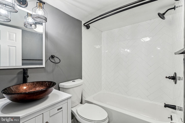 full bathroom featuring tiled shower / bath combo, vanity, and toilet