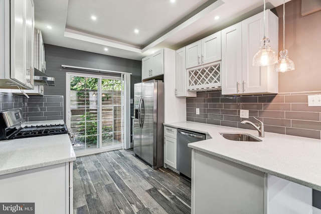 kitchen with dark hardwood / wood-style floors, sink, white cabinets, stainless steel appliances, and decorative light fixtures