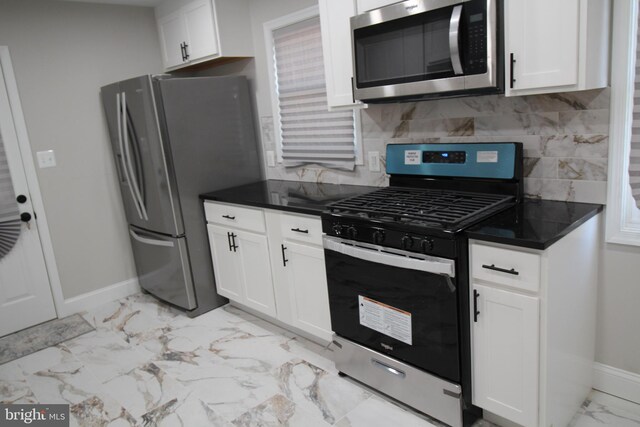 kitchen featuring decorative backsplash, appliances with stainless steel finishes, sink, and white cabinetry