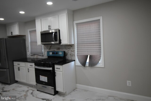 kitchen featuring stainless steel appliances, sink, tasteful backsplash, and white cabinetry