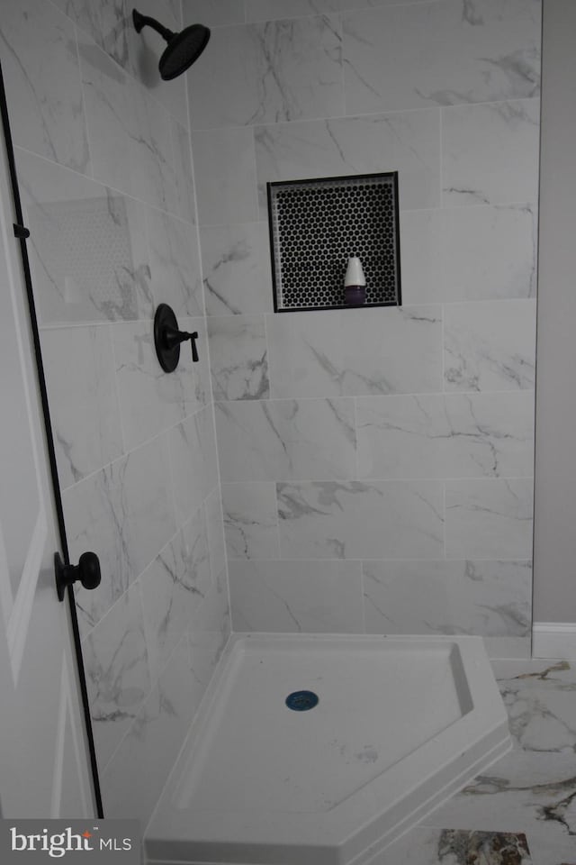 full bath featuring marble finish floor and a shower stall