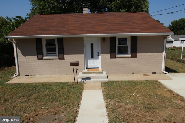 bungalow featuring crawl space, brick siding, and a front lawn