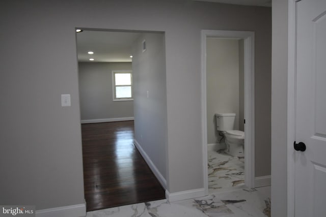 hall with recessed lighting, marble finish floor, and baseboards