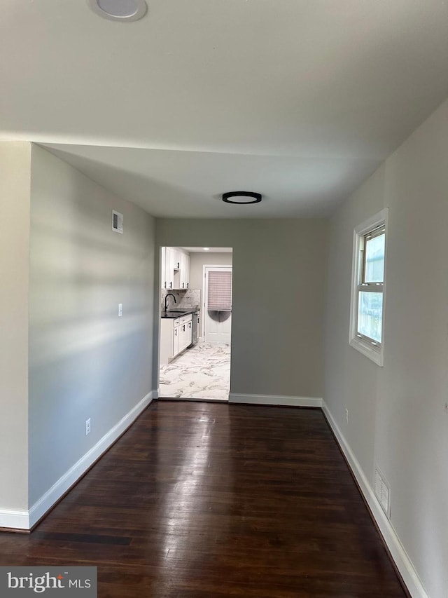 empty room with dark wood-type flooring and sink