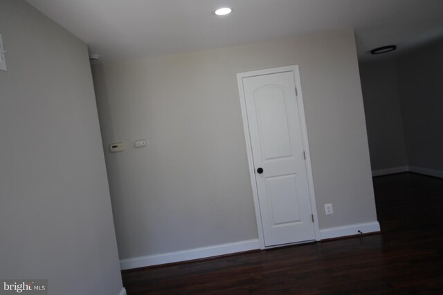 unfurnished room featuring dark wood-type flooring