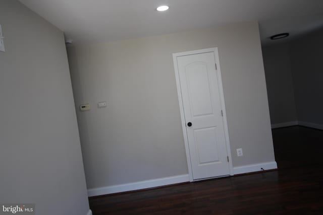 unfurnished room featuring dark wood-style floors, recessed lighting, and baseboards