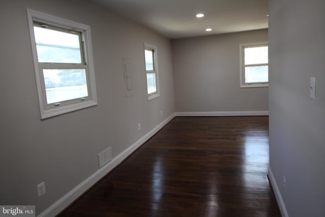 unfurnished room featuring dark wood-type flooring, recessed lighting, visible vents, and baseboards