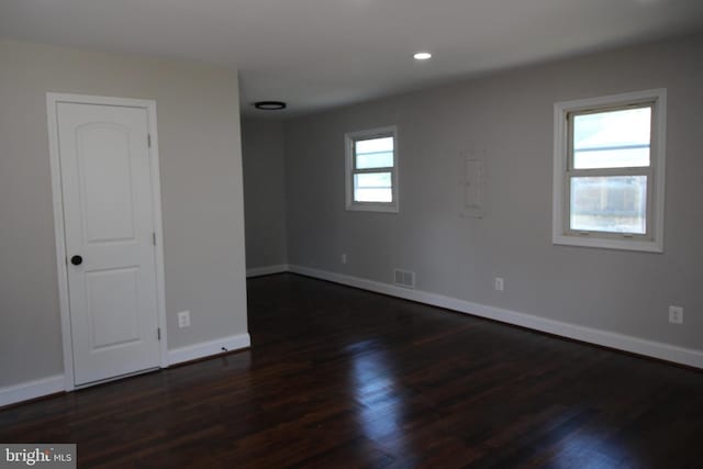 unfurnished room with recessed lighting, dark wood-style flooring, visible vents, and baseboards