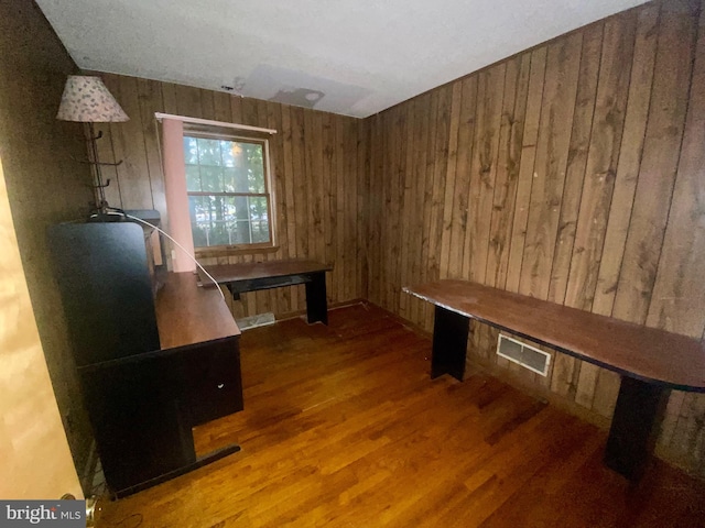 misc room featuring wooden walls and dark wood-type flooring