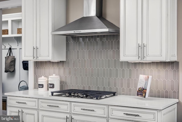 kitchen featuring wall chimney exhaust hood, decorative backsplash, and white cabinetry