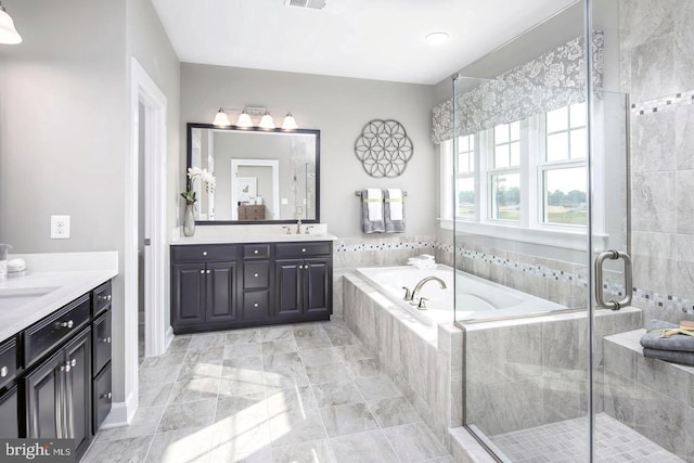 bathroom featuring tile patterned flooring, vanity, and shower with separate bathtub