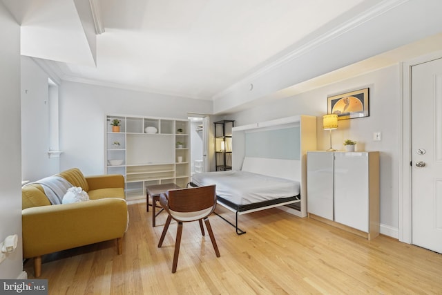 bedroom with crown molding and wood finished floors