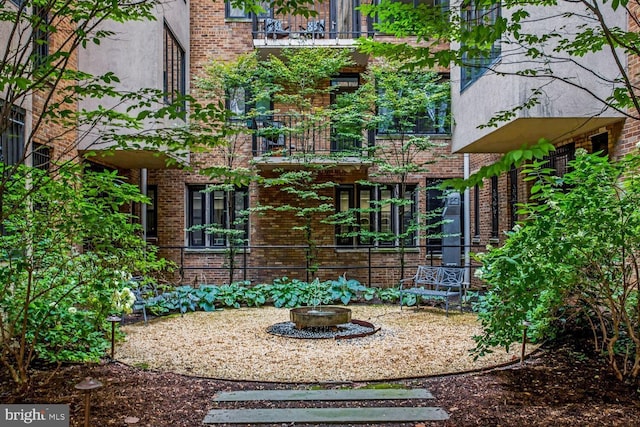 exterior space featuring brick siding and stucco siding