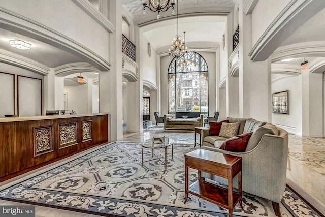 interior space with arched walkways, marble finish floor, a notable chandelier, and a towering ceiling