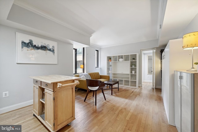 interior space with light wood-style flooring, baseboards, and crown molding