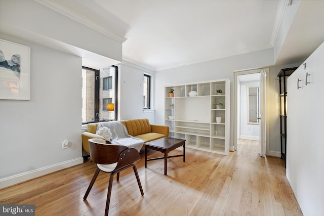 living room with light wood-style floors, baseboards, and ornamental molding