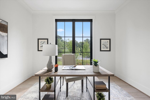 home office with light hardwood / wood-style floors and ornamental molding