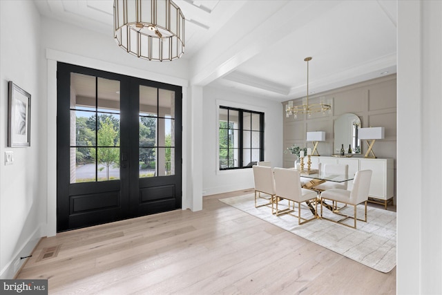 foyer with a wealth of natural light, a chandelier, and light wood-type flooring