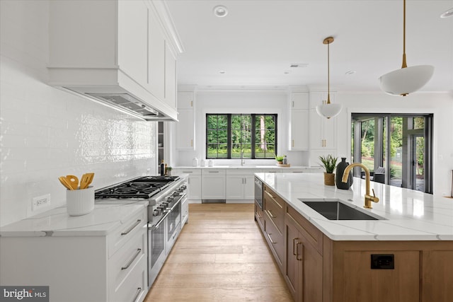 kitchen featuring white cabinetry, sink, decorative light fixtures, and double oven range