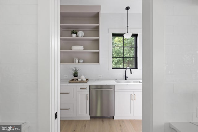 bar with dishwasher, decorative light fixtures, light hardwood / wood-style flooring, sink, and light stone countertops