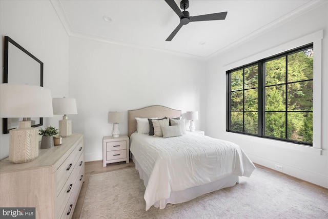 bedroom featuring ceiling fan, light hardwood / wood-style flooring, and crown molding