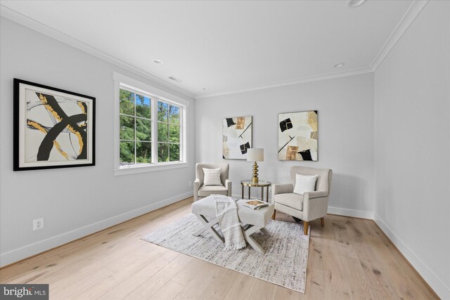 living area featuring light hardwood / wood-style flooring and ornamental molding