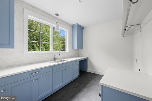 kitchen with backsplash, sink, and pendant lighting