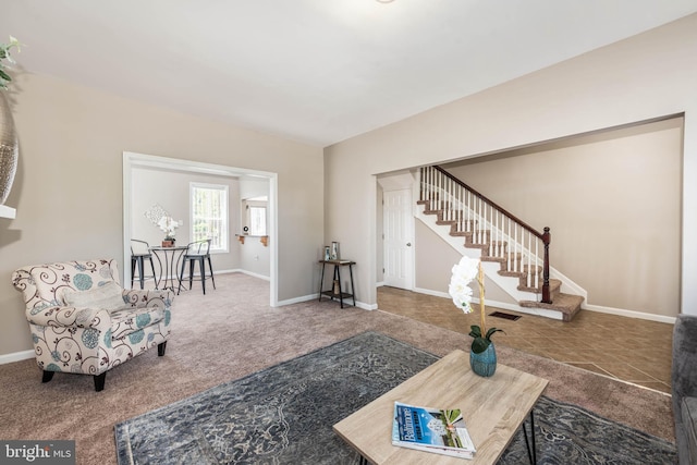 carpeted living room with visible vents, stairway, and baseboards