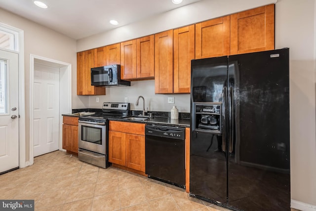 kitchen with black appliances, brown cabinets, a sink, and recessed lighting