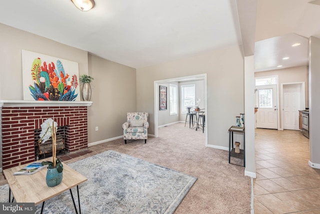 living area featuring light tile patterned flooring and a brick fireplace