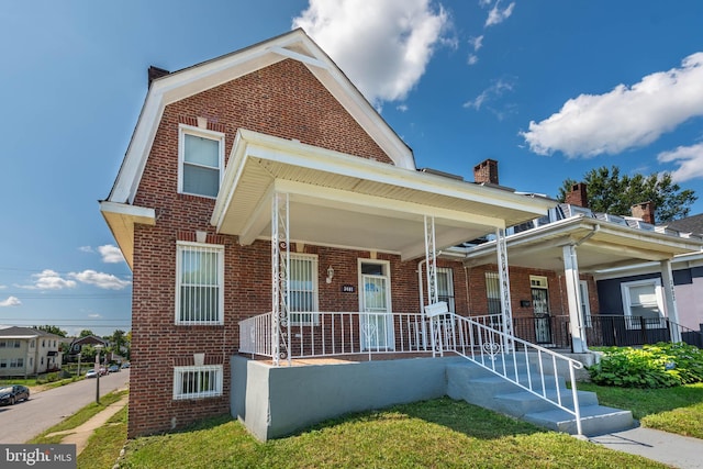 view of front facade featuring covered porch and brick siding