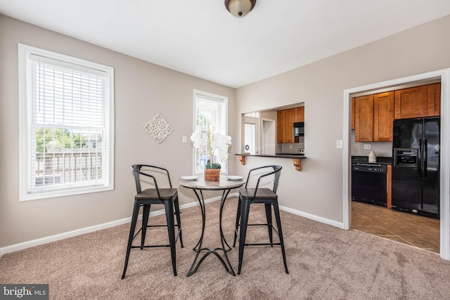 dining room with light colored carpet and baseboards