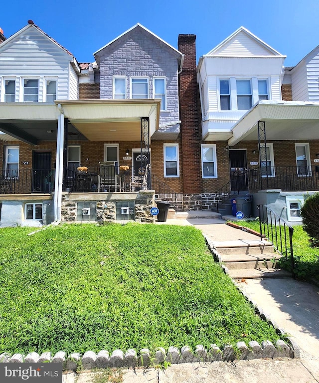 view of front of house with a front yard and covered porch