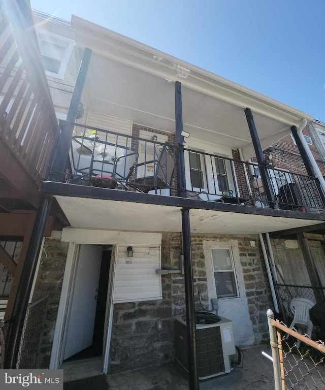 rear view of property with central AC and a balcony