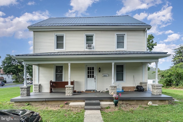 view of front of house with a front yard, cooling unit, and covered porch