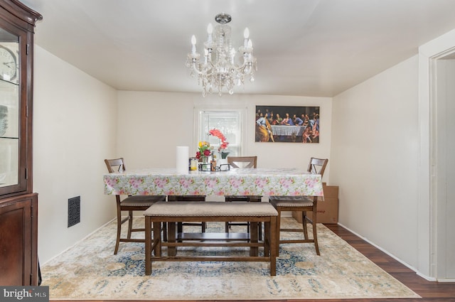 dining room with hardwood / wood-style floors and a chandelier