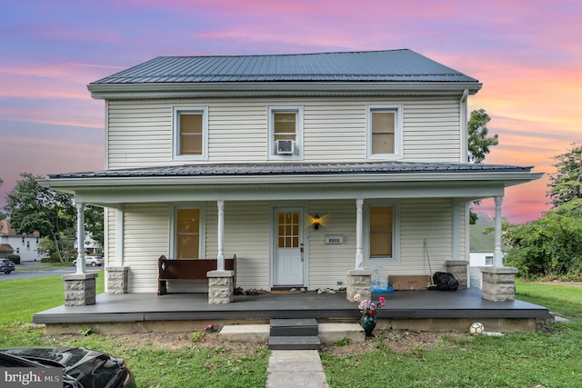 view of front of house with cooling unit, a porch, and a lawn