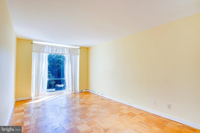 empty room with a wealth of natural light and light parquet floors