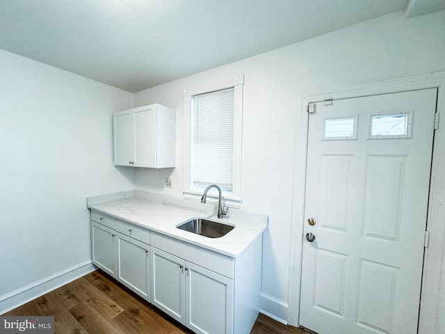 kitchen with sink, dark wood-type flooring, light stone counters, a healthy amount of sunlight, and white cabinets